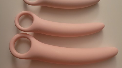 Image of various sized dilators that I use. They are pink silicone and have a loop at the end for a finger to hold. The other end is slightly tapered and the lengths of each are slightly curved.