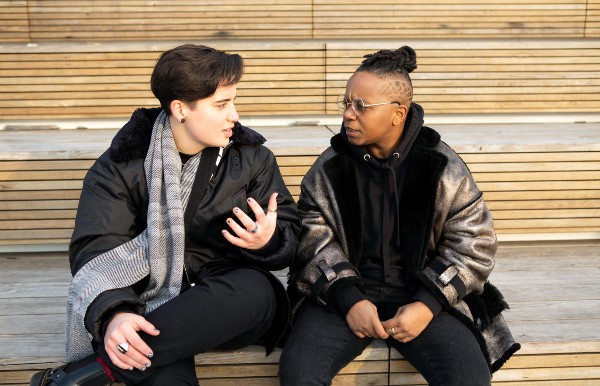 Two people sitting together outside and having a serious conversation. This represents Denise having conversations with different LS warriors.