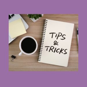 Image of a notepad with 'tips and tricks' written with a bold, black market. Next to the book is a cup of coffee, a pen, and office supplies.