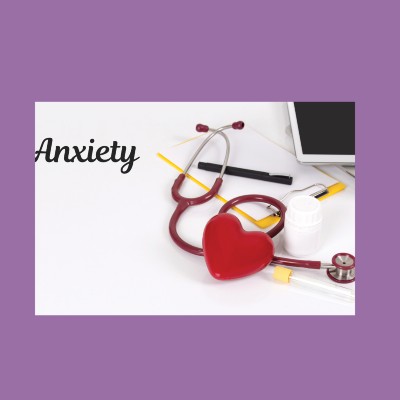 Small pile of medical supplies, including a stethoscope, pen and pad, and tablet computer, on a white desk with the word 'anxiety' in black cursive font to the left, representing the concept of health anxiety and lichen sclerosus.