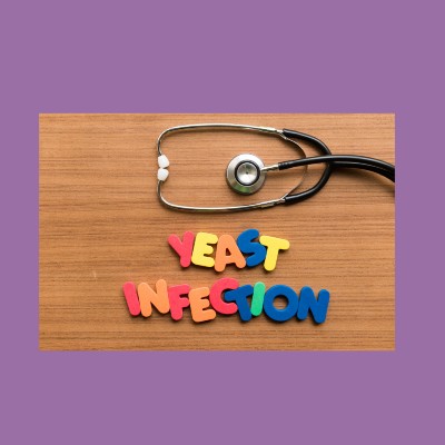 Image of a wood table with a stethoscope and the words 'yeast infection' spelled out in colorful block letters.