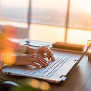 Image of a person typing on a computer, working on their blog.