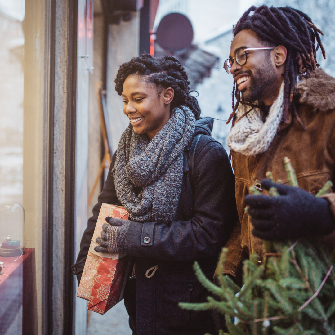 Black couple shopping together for Christmas trees.